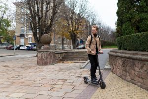 male riding an electric scooter