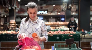 woman picking fruits up at trader joes