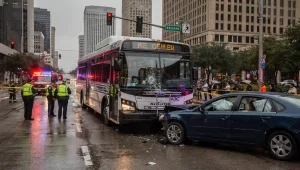 METRO bus navigating a busy Houston intersection with pedestrians crossing